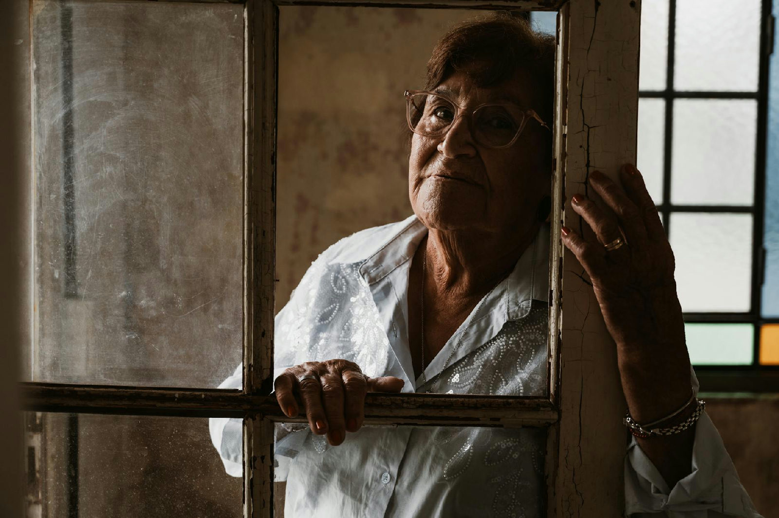 Mulher olhando pela janela em um momento de reflexão sobre as datas difíceis no luto, recebendo apoio de uma psicóloga em Cu…