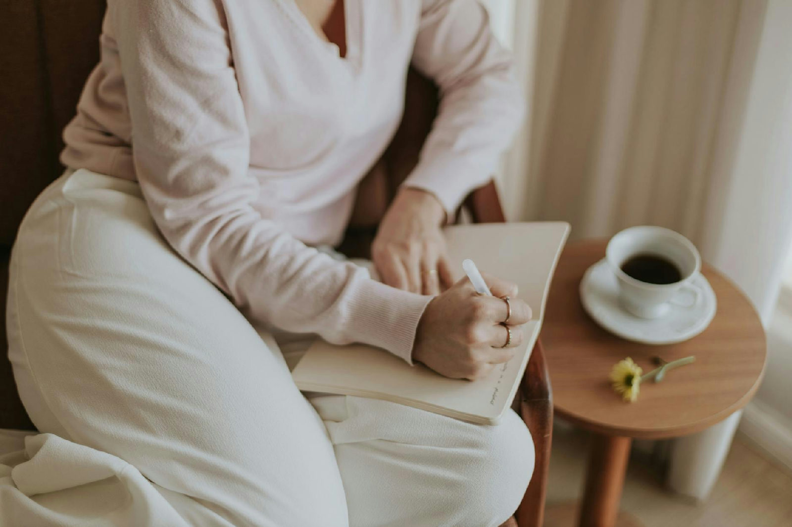 Mulher sentada em sua mesa, pensativa, refletindo sobre como quebrar o ciclo da procrastinação com ajuda de uma psicóloga.