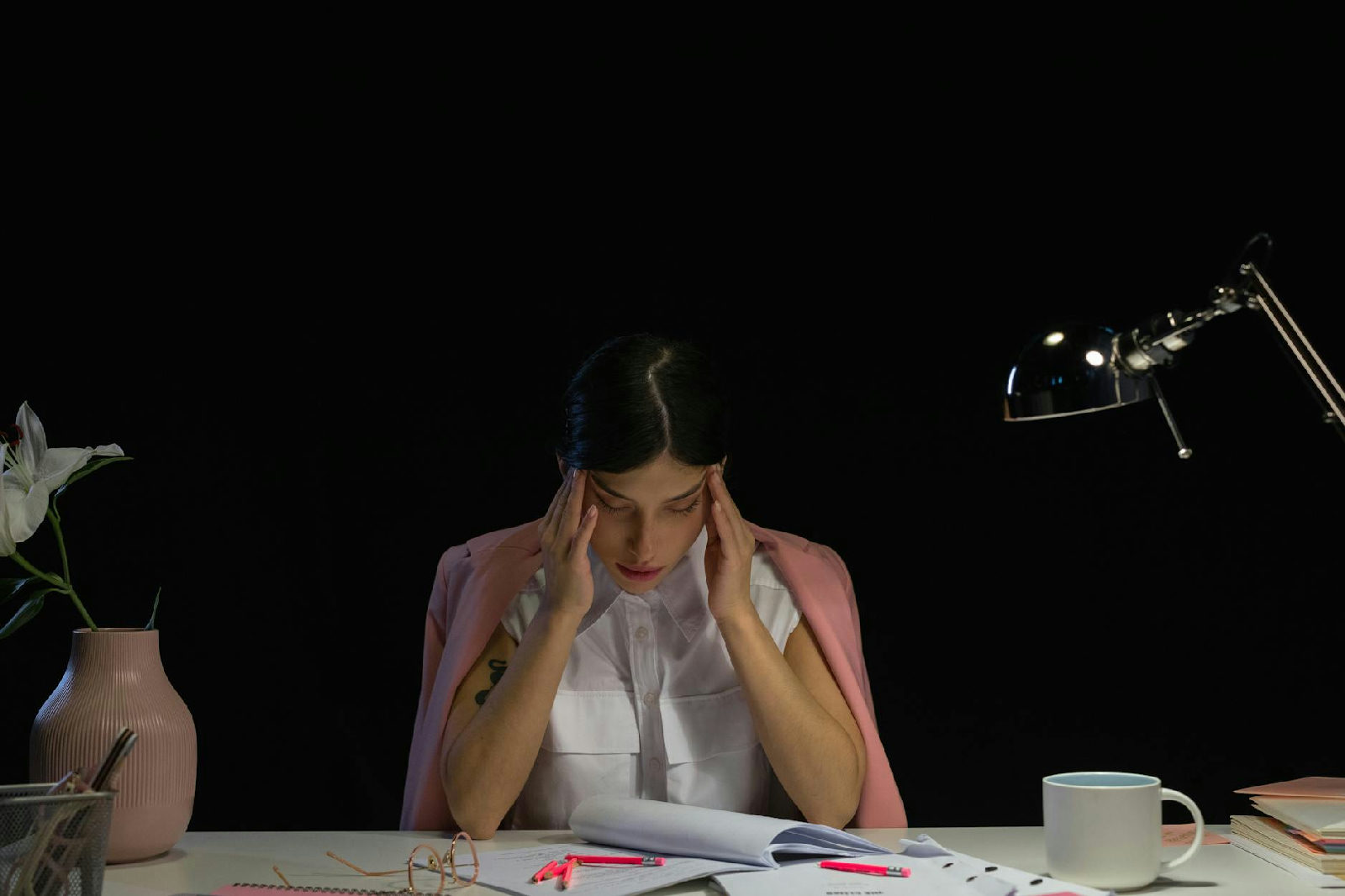 professional woman looking stressed but trying to hide it in office environment, candid, soft natural light — A woman sittin…